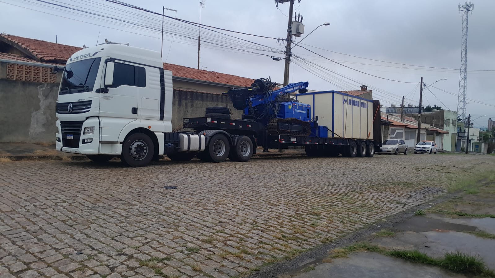 Caminhão Meteor com carreta prancha transportando equipamento de bate-estaca Andrade Mello