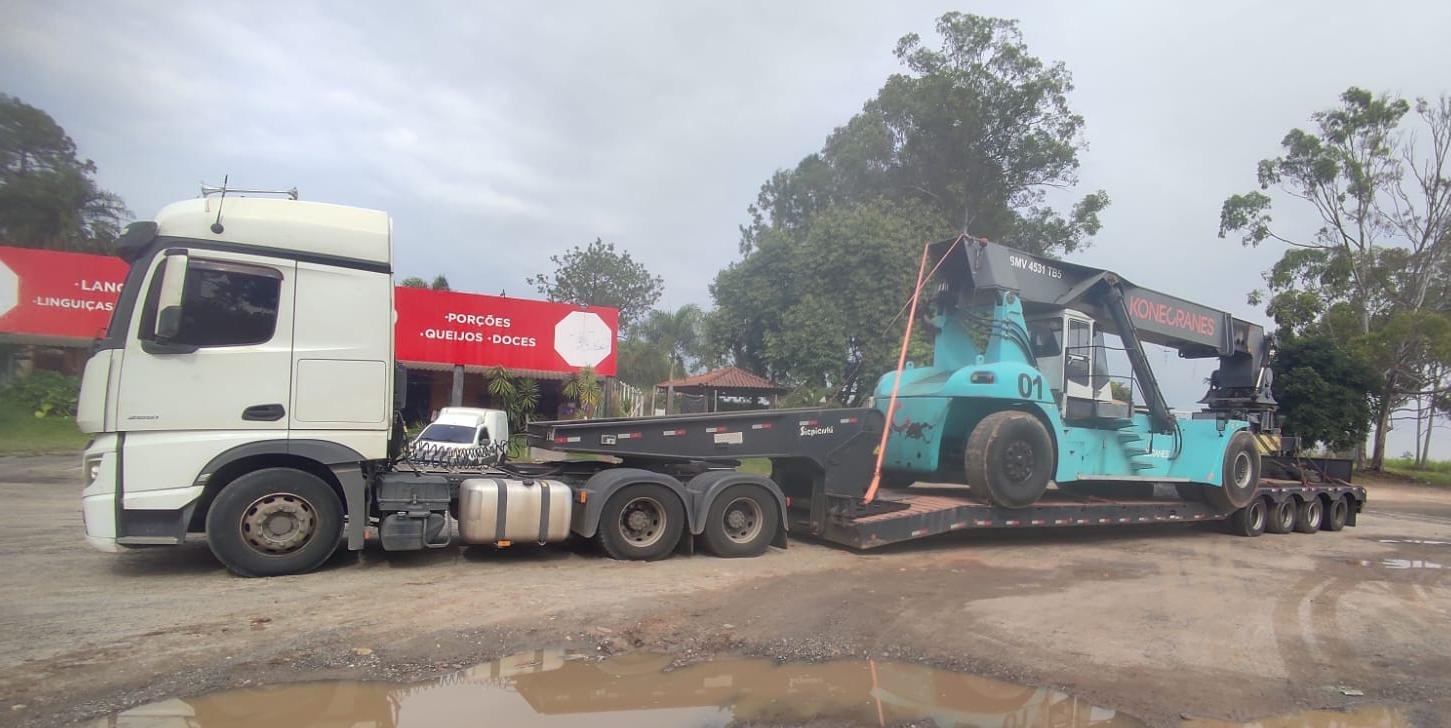Caminhão Actros com carreta prancha rebaixada transportando Reach Stacker Konecranes retirado em porto